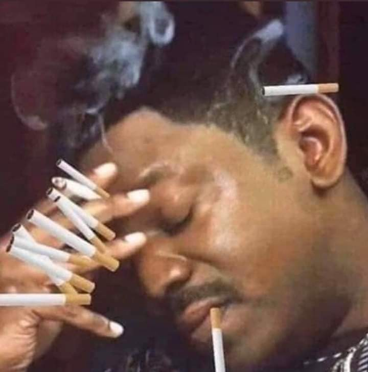A man with dozens of lit cigarettes stacked across his face