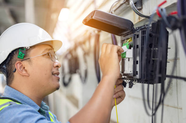A technician inspecting electrical and network equipment