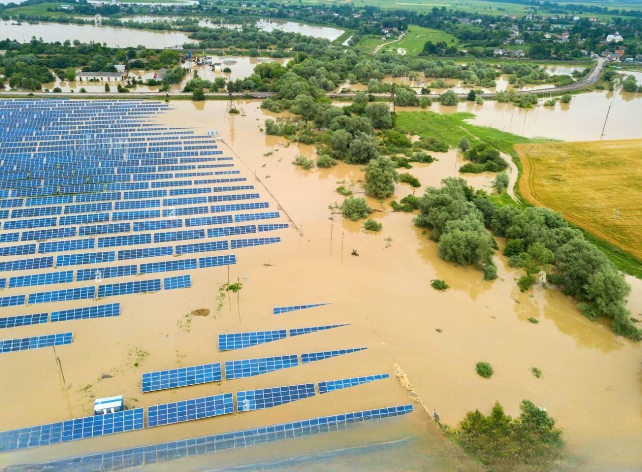 Aerial view of a ground-mounted solar farm submerged by floodwater