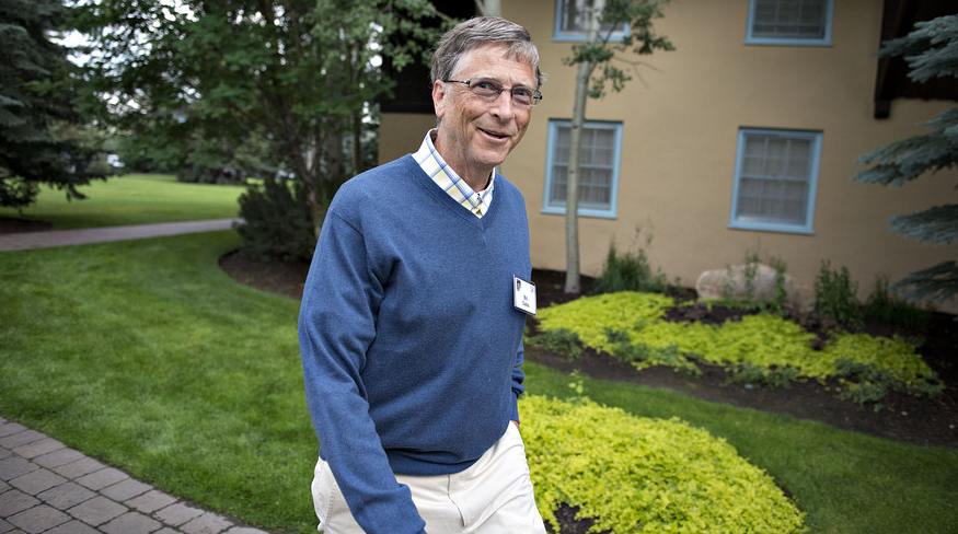 Bill Gates walking across a lawn at a conference