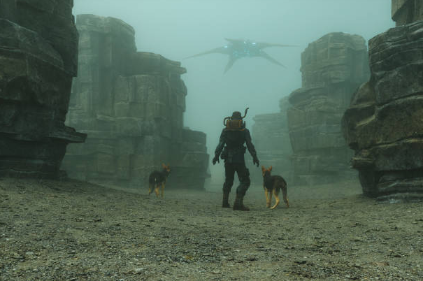 A lone figure flanked by two dogs in a foggy canyon (unkown)